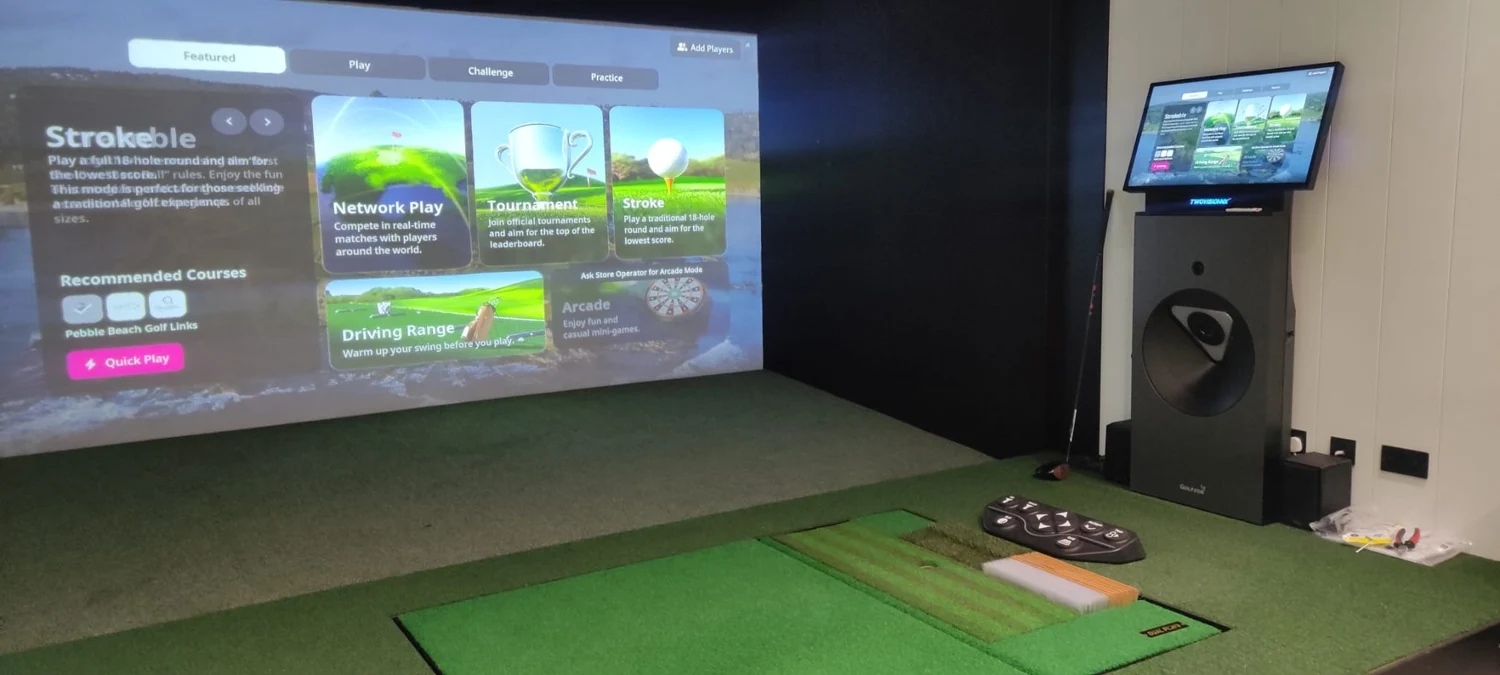 Garden golf simulator room with a wall-mounted television and putting green