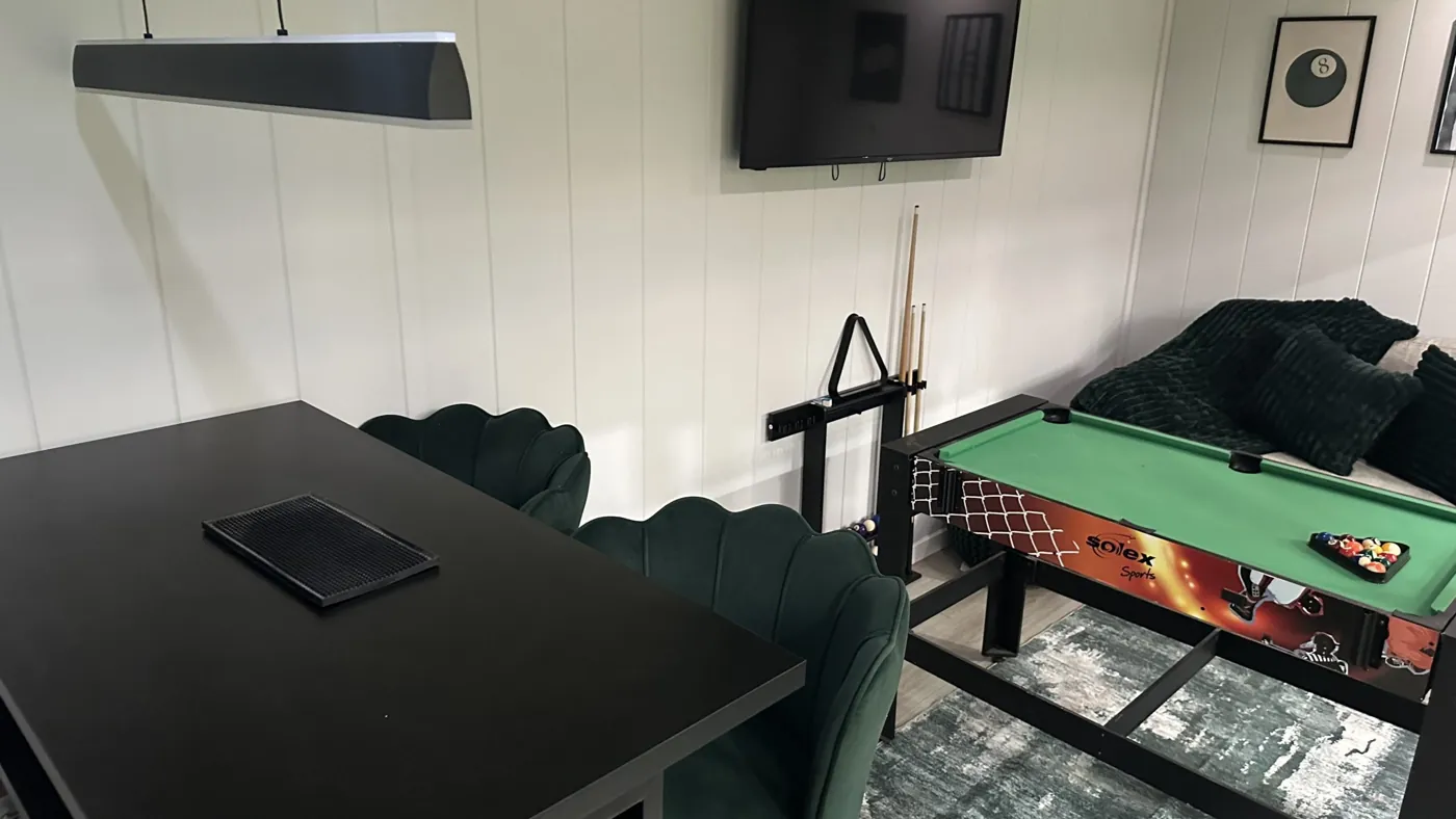 Showroom games room display with a pool table, dining table and television