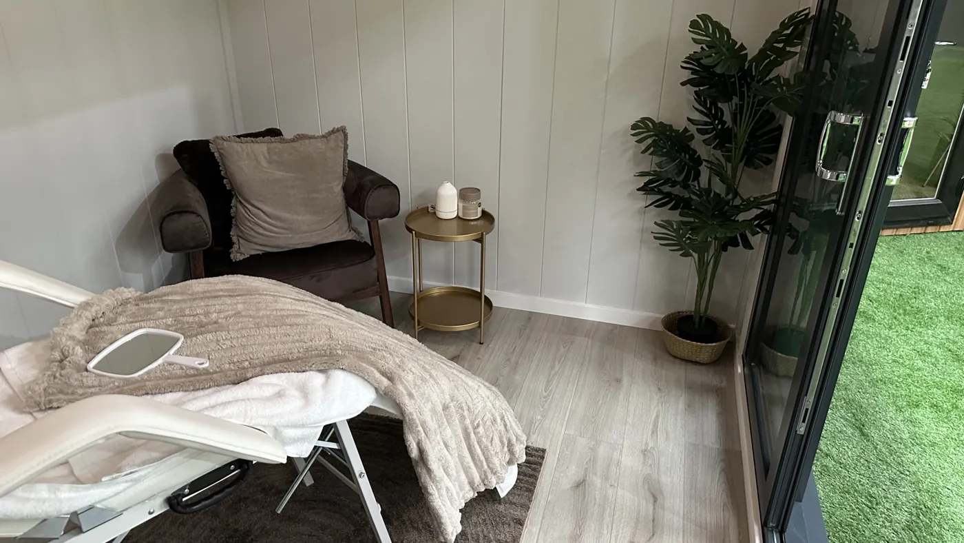 Relaxation room display with an armchair, treatment couch and plants in the Noah showroom