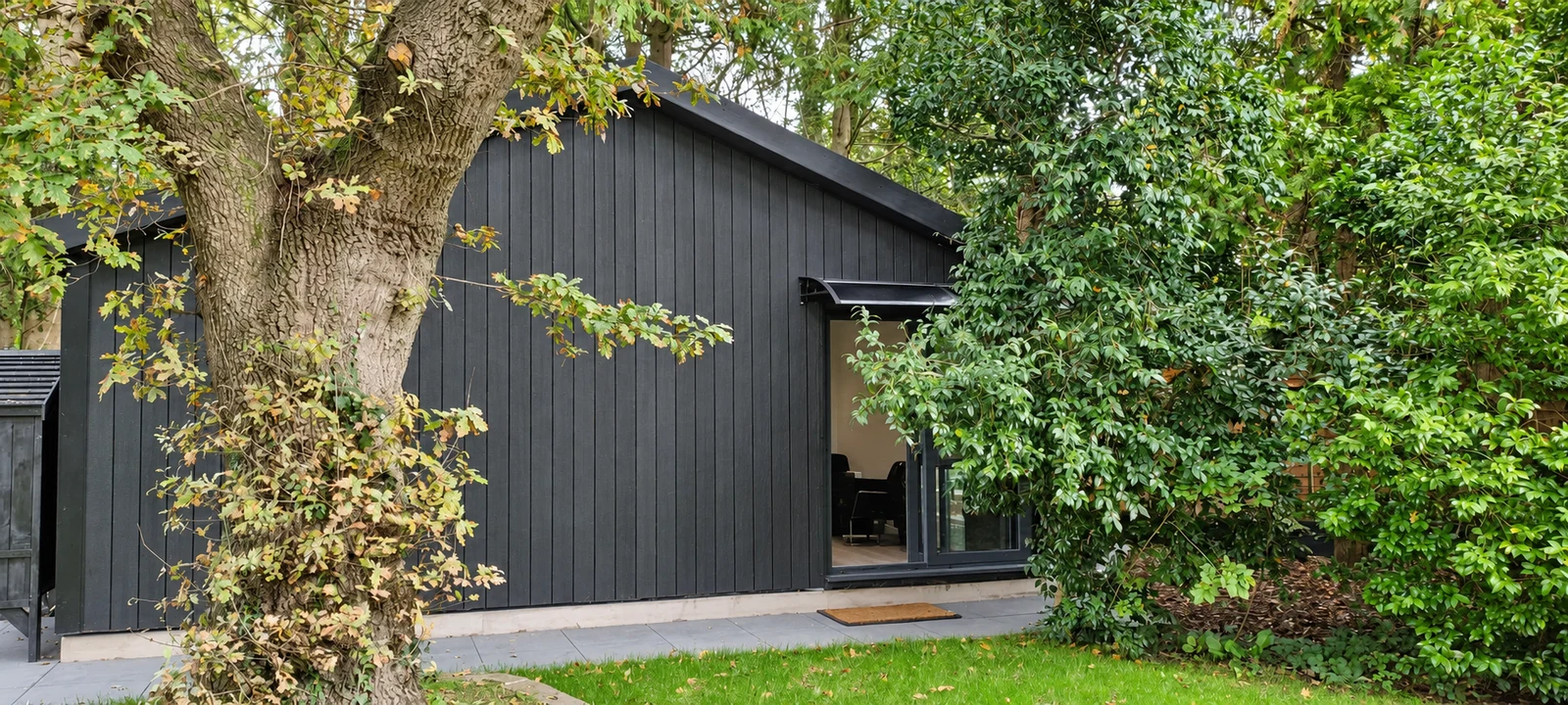 Composite-clad Noah garden building among mature trees in Cardiff