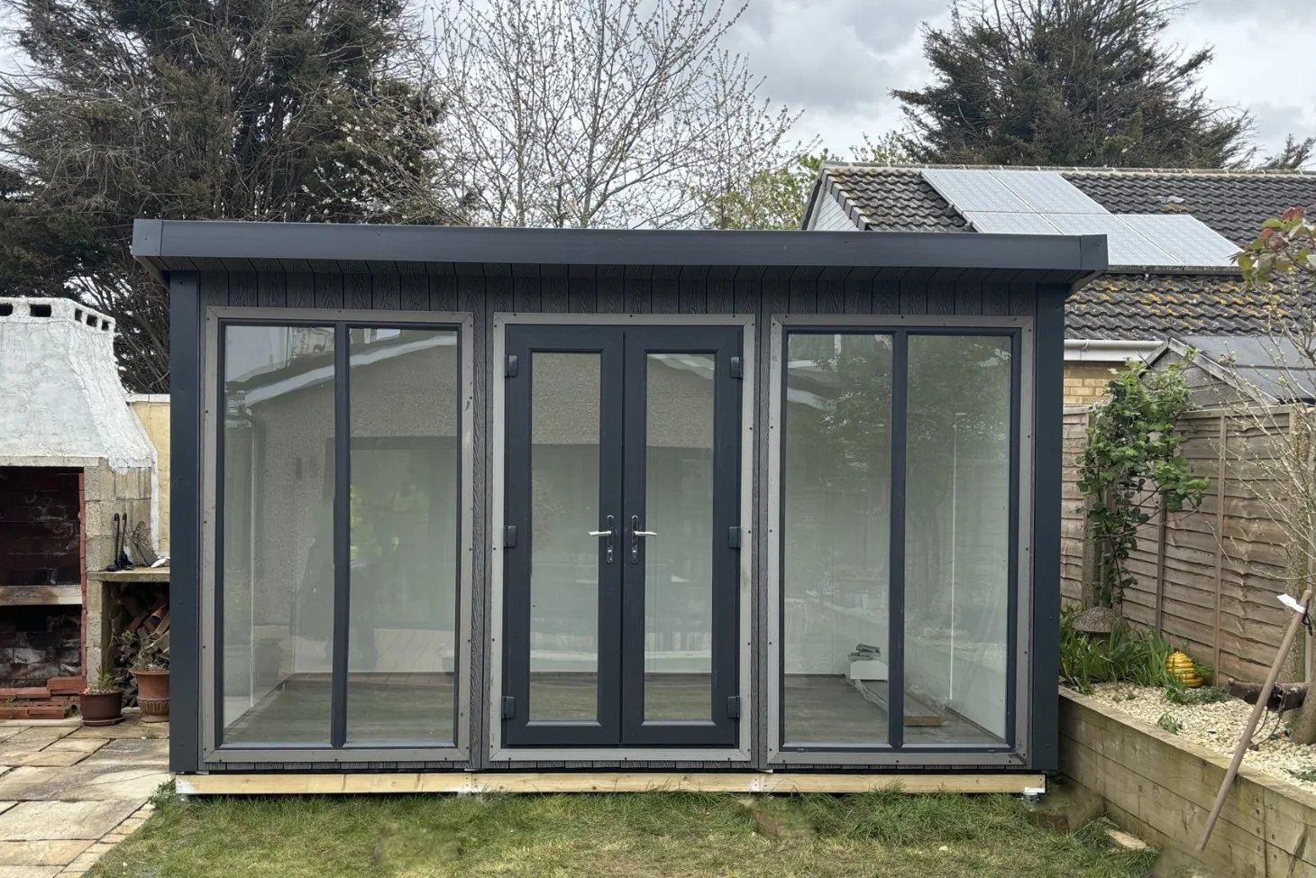 Dark composite Noah garden room with a pair of French doors between fixed glazed panels