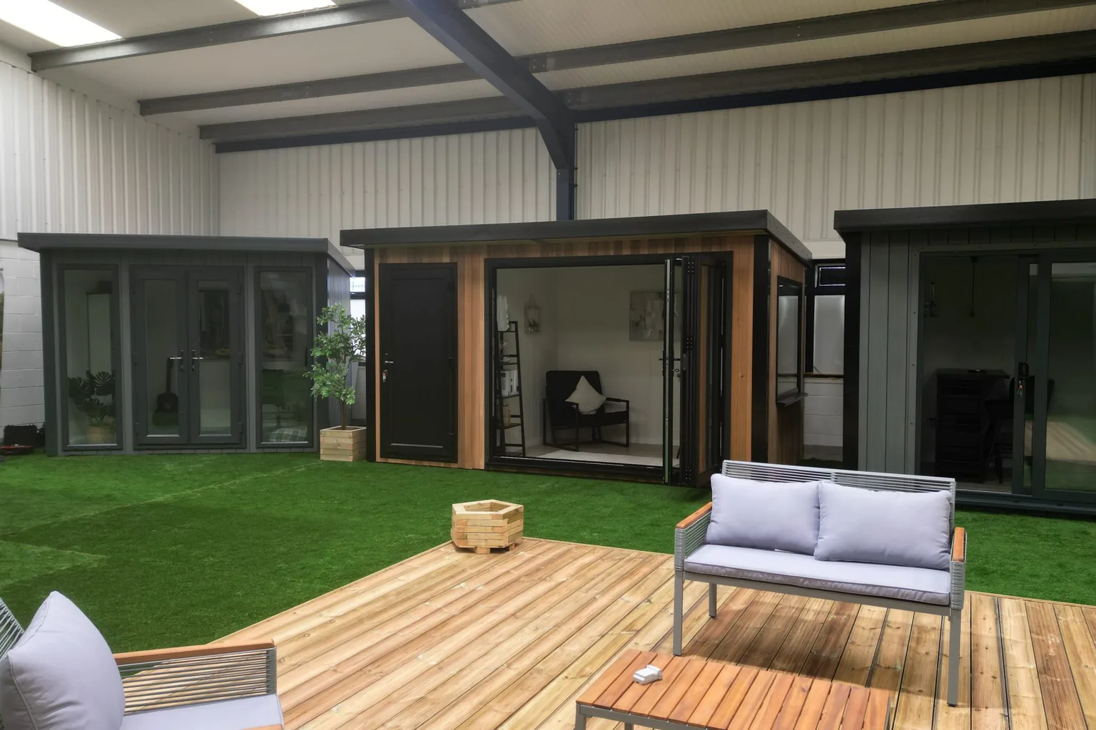 The Noah indoor showroom, with lit display garden rooms around a timber deck and sofa